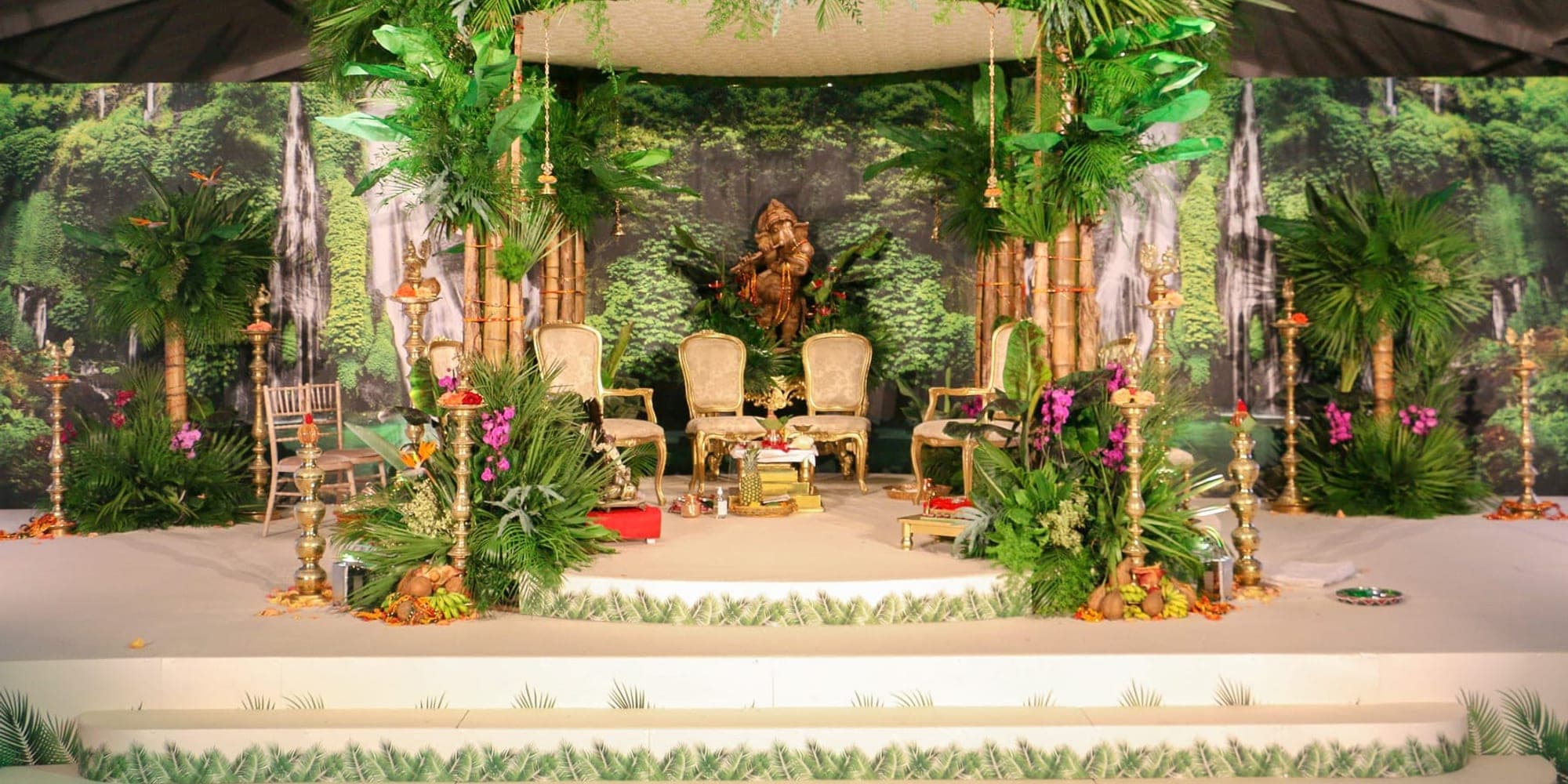 Tropical bamboo and palm canopy wedding mandap on a round white stage