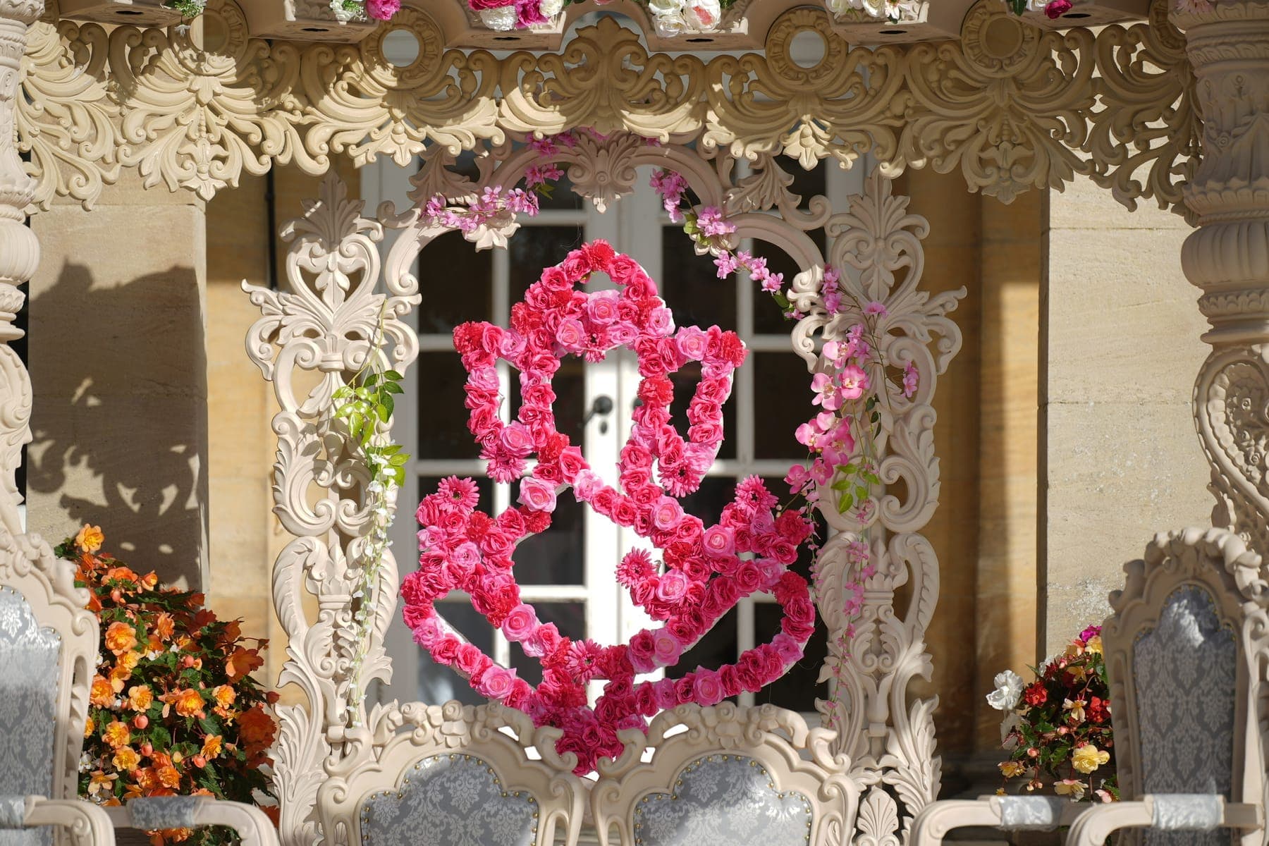 Cream scrollwork frame with a pink rose Ganesh motif and grey damask chairs
