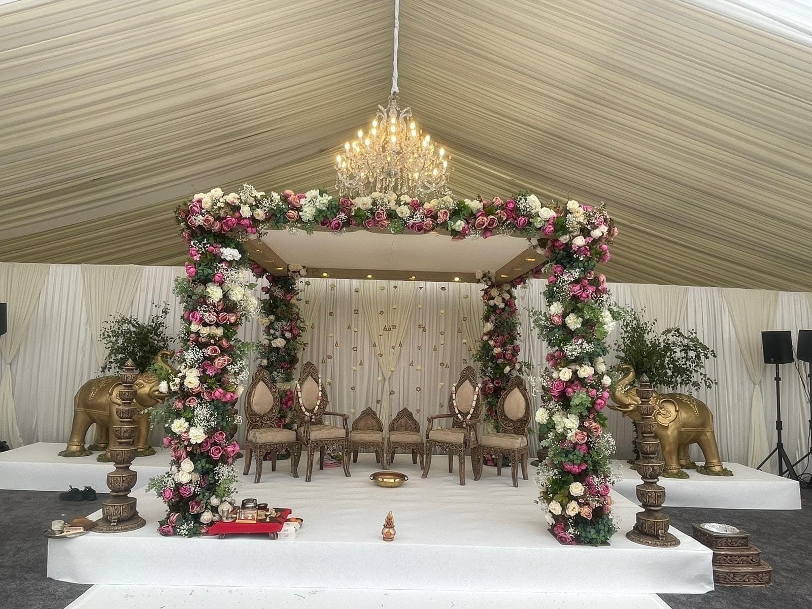 Floral square frame with elephant figures on a white stage inside a marquee